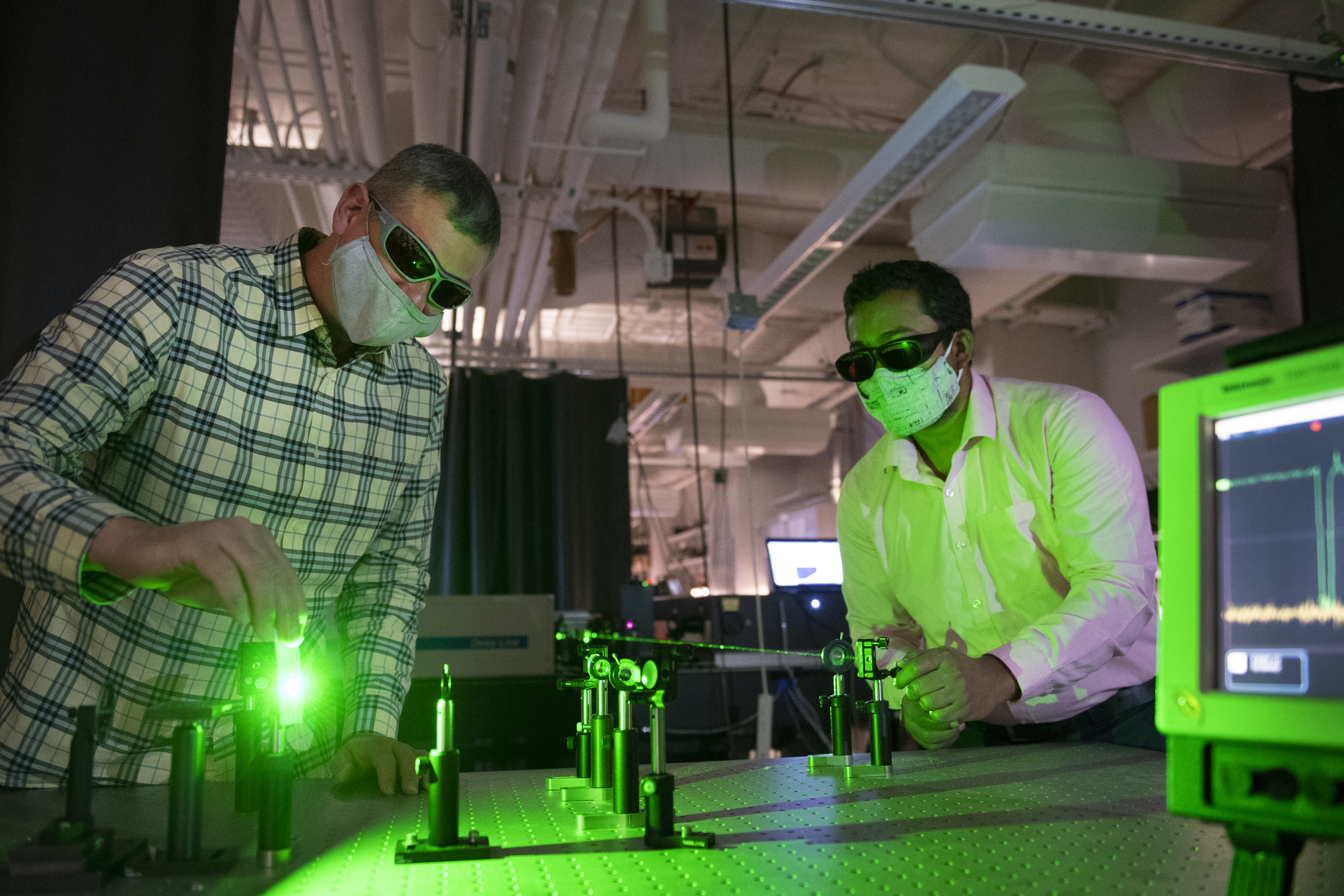Dr. Nathan Hammer and his student working with laser equipment