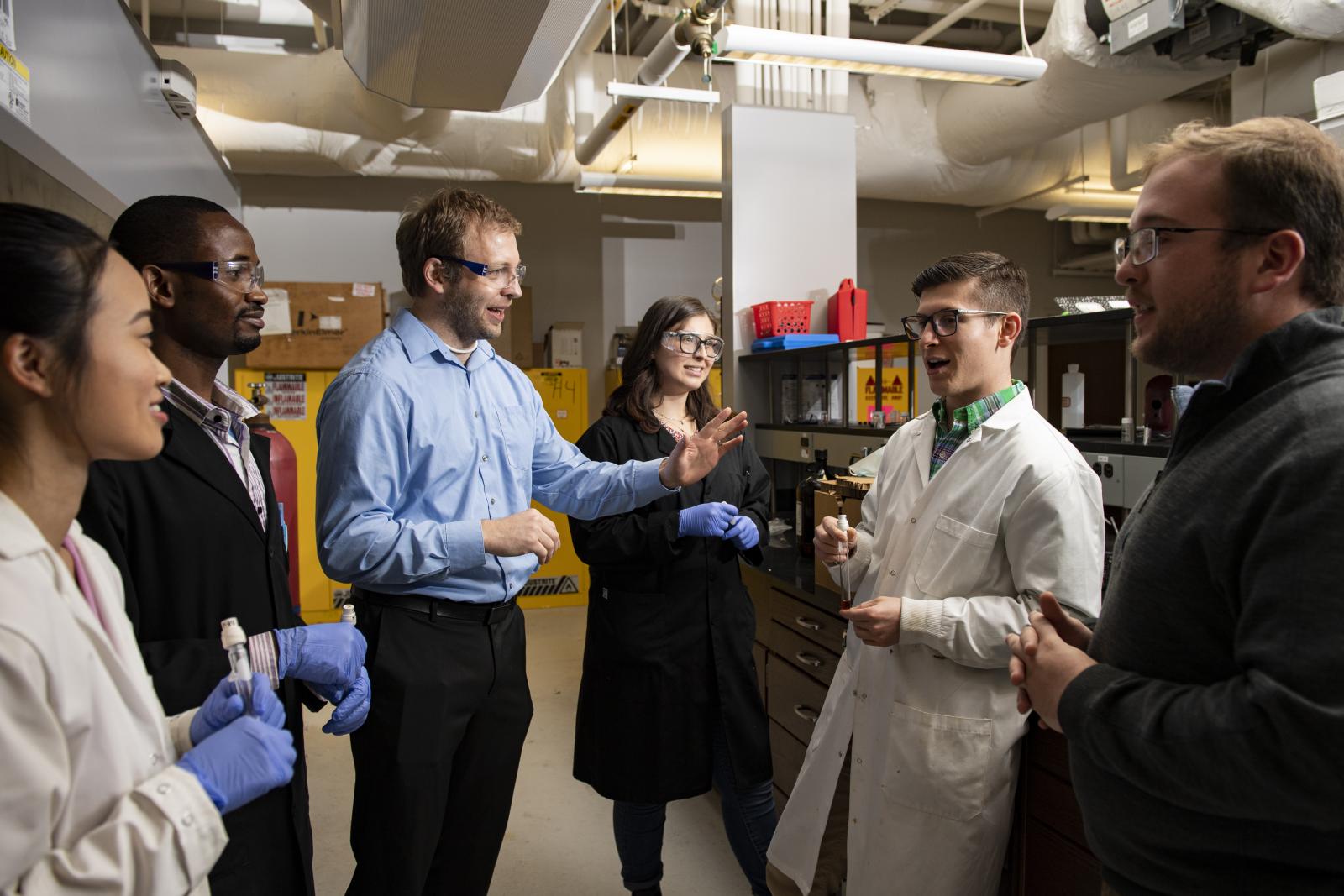 Dr. Jared Delcamp in discussion with his lab students