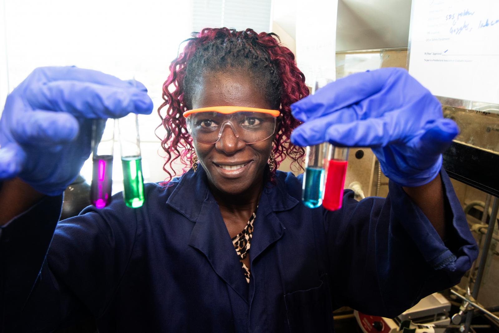 Colleen Scott holding test tubes filled with different colored liquids